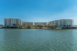 Hotel na orla marítima com várias varandas, piscina e vista desobstruída para a água.