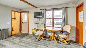 A room with a wooden floor, two wooden chairs, a small table, a television on the wall, and a window with curtains. - 5 Mi to Rice Lake State Park: Lake Mills Studio (Lake Mills)