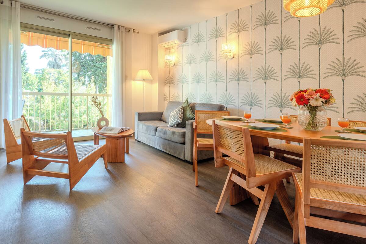 Un espace repas avec des meubles en bois, un canapé et une vue dégagée grâce à de grandes fenêtres.