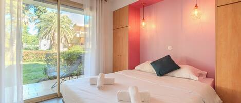 Un dormitorio con una cama grande, vistas al exterior y una puerta corrediza de vidrio.