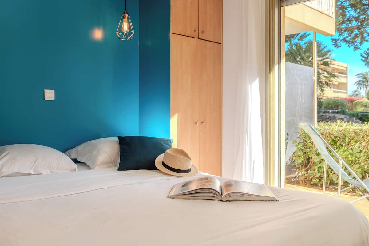 Une chambre à coucher avec un lit, un chapeau et un livre ouvert.