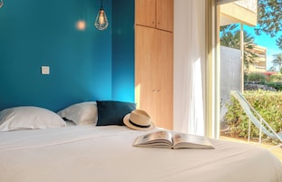 A bedroom with a bed, a hat, and an open book.