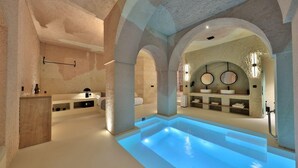 A modern spa with a central pool, stone walls, and minimalist decor. - Simurg Cave House (Urgup)