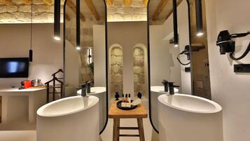 Un baño moderno con dos lavamanos, un taburete de madera y un espejo.