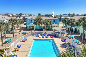 A pool area with lounge chairs and a fenced pool. - Blessed Getaway Stay for 10! (Port Aransas)