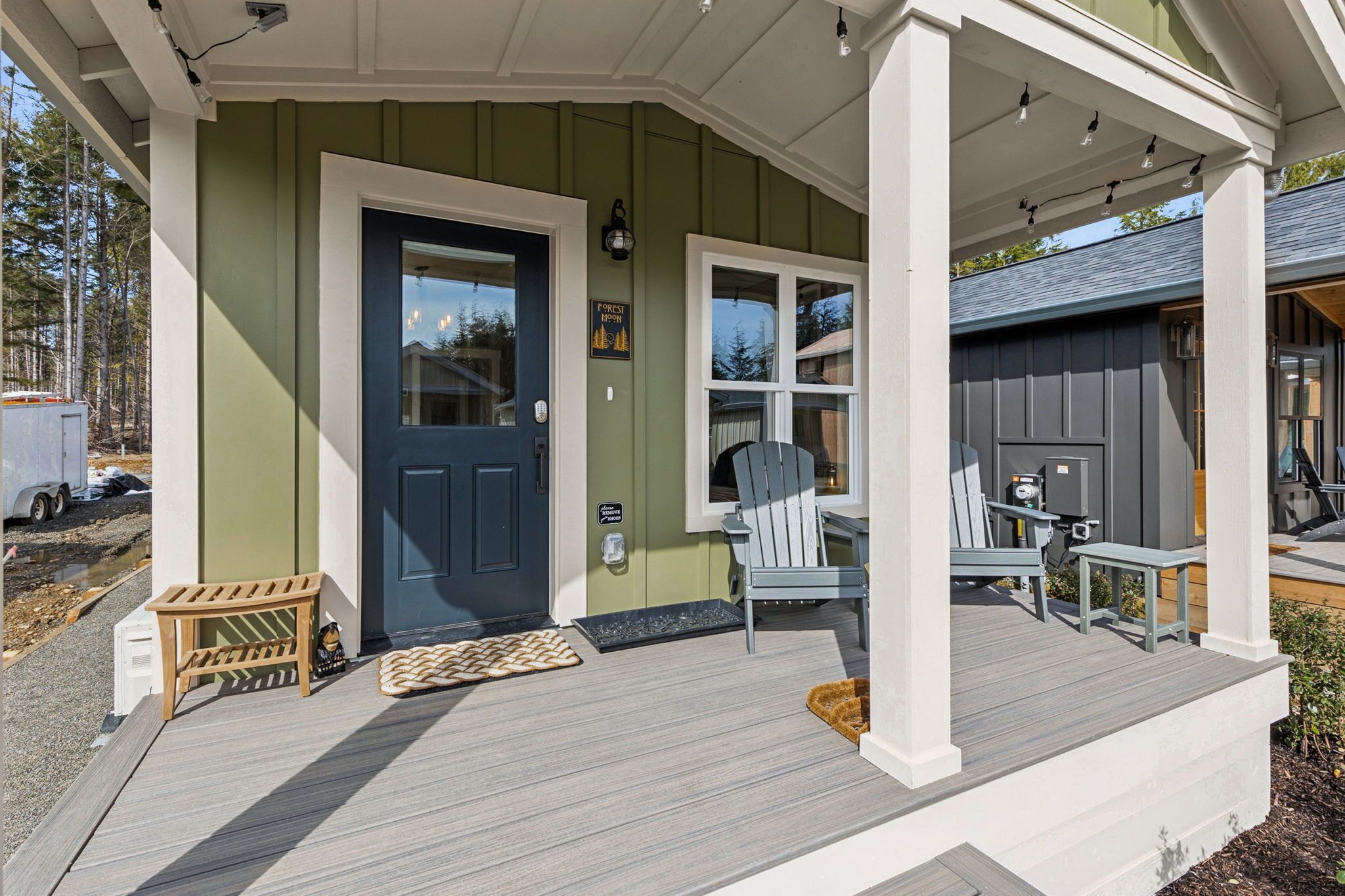 A house with a porch, a dark blue door, and a light blue chair.