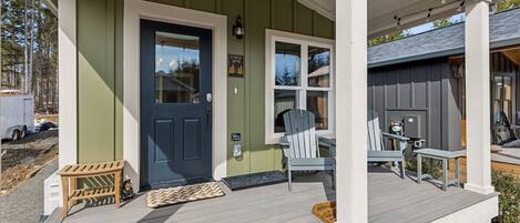 A house with a porch, a dark blue door, and a light blue chair.