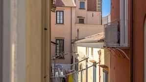 Un estrecho callejón flanqueado por edificios, incluyendo una torre con reloj y campana.