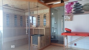 A corner room with a glass partition, wooden shelving, a massage table, and a stone wall decoration. - Luxury house: sauna, turk. Steam bath, Jacuzzi, whirlpool, fireplace - Polish Baltic Sea (Pogorzelica)