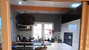 A modern kitchen with a central island, bar stools, and a large window. - Luxury house: sauna, turk. Steam bath, Jacuzzi, whirlpool, fireplace - Polish Baltic Sea (Pogorzelica)