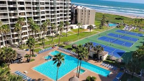 Un hotel con piscina, campi da tennis e vista sulla spiaggia.