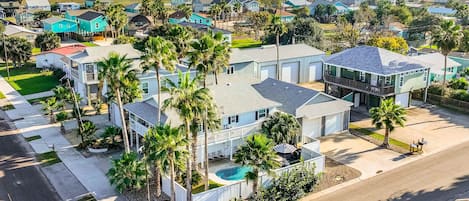Zona residencial con casas, palmeras y una piscina.