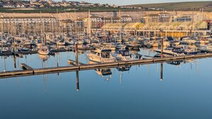 Un port de plaisance où sont amarrés de nombreux bateaux, entouré d’immeubles d’habitation.