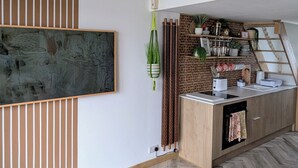 Une cuisine moderne avec un plan de travail en bois, des plantes suspendues et un four encastré.