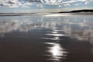 A beach with calm waters reflecting the sky. - The Mill set in stunning rural Northumberland (Netherton)
