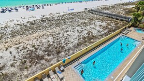 Blick auf einen Strand mit Schwimmbecken und Liegestühlen.