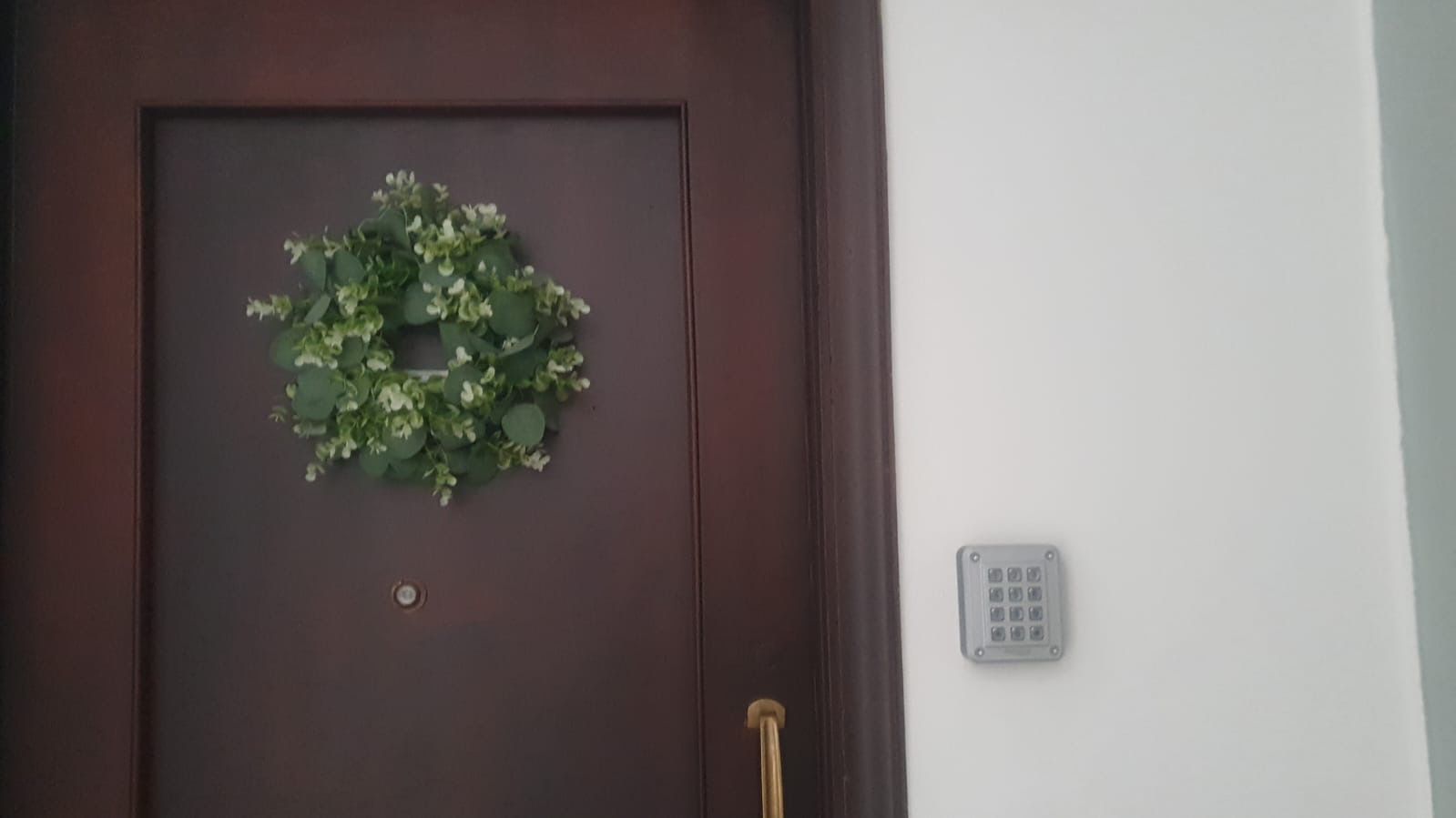 A closed door with a metal handle and a small circular lock.