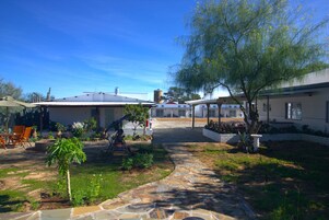 Una zona residencial con un patio, mobiliario exterior y un camino de piedra.