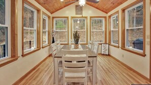 A dining area with a wooden ceiling, large windows, and a ceiling fan. - Wellsboro Woods Retreat - Near 2 State Parks (Middlebury Township)