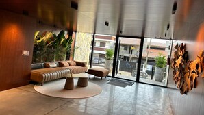 Eine moderne Lobby mit einer Couch, einem Couchtisch und Topfpflanzen.