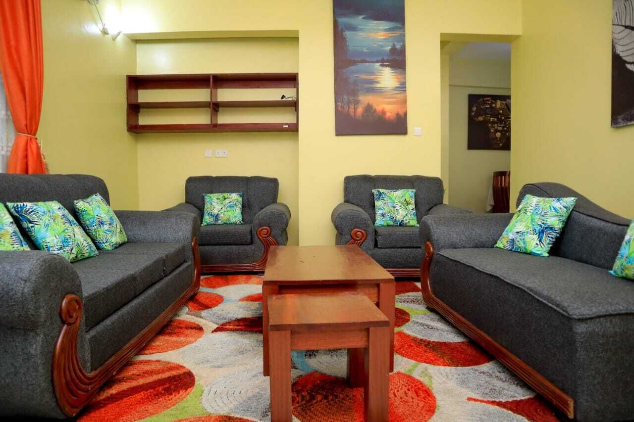 A living room with two sofas, a coffee table, and a wall-mounted shelf.