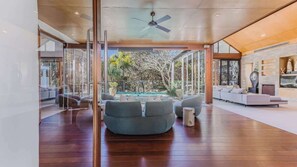 A modern interior with a pool, seating area, and a fireplace. - Santi House (Kingscliff)