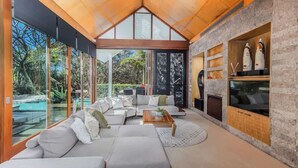 A modern living room with a large sofa set, a coffee table, and a fireplace. - Santi House (Kingscliff)