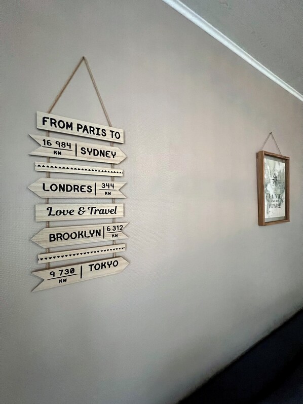 A wall with a travel-themed signpost listing distances to various cities. - Cosyflat Cherbourg (Cherbourg-en-Cotentin)