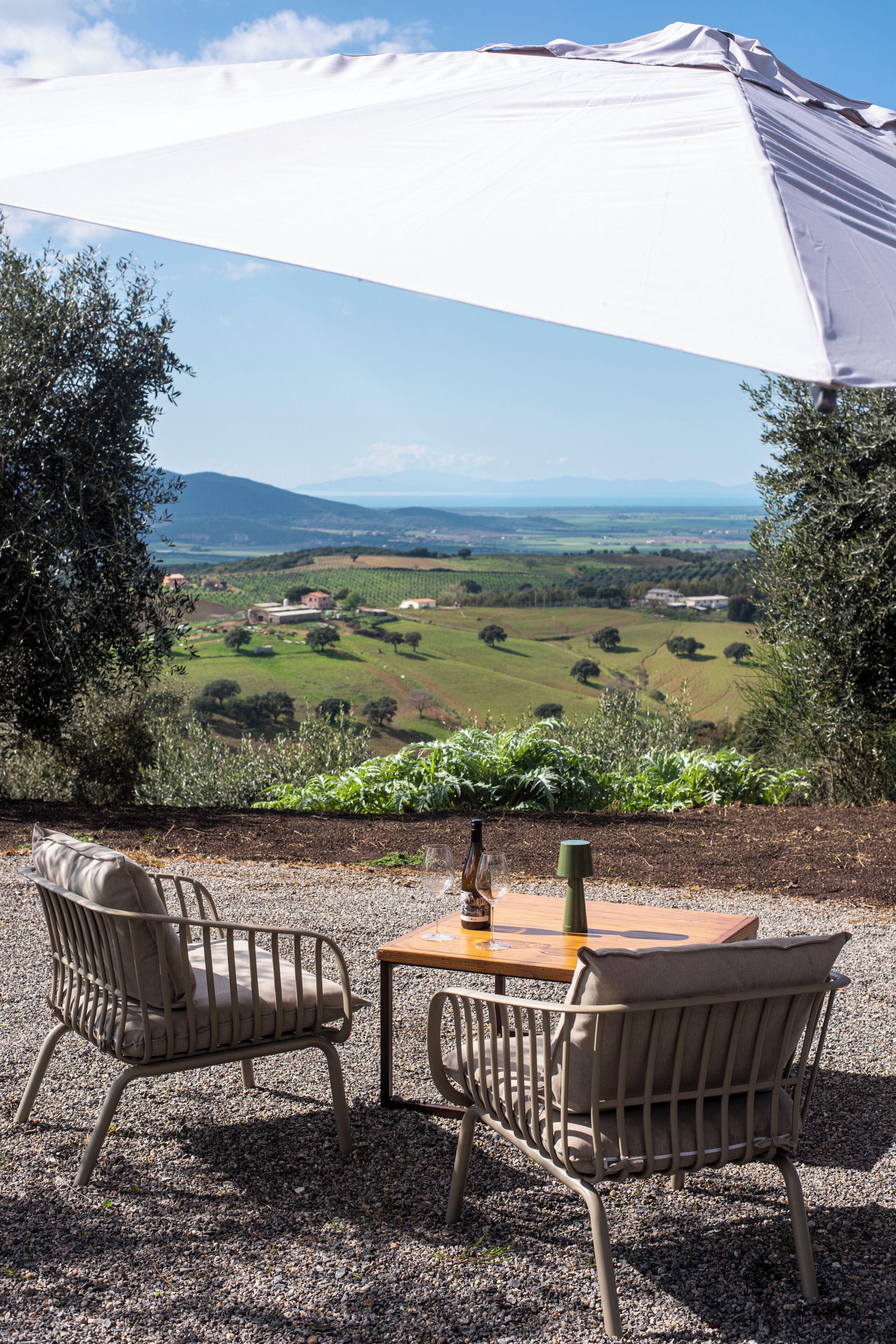 An outdoor seating area with two chairs and a table, overlooking a scenic landscape.
