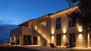 A modern house with a spacious patio, a staircase, and outdoor seating.