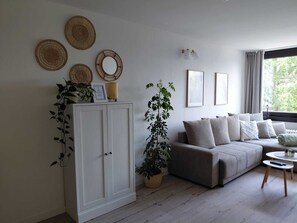 A living room with a sofa, a cabinet, and a potted plant.