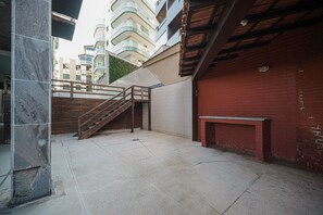 Ein Innenhof mit Treppe, Bank und einer roten Backsteinmauer.