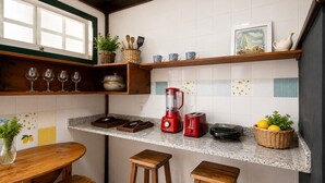 A kitchen with a granite countertop, wooden stools, a red blender, a toaster, and a basket of lemons. - Bz39 House with private pool 300m from the beach! (Armação dos Búzios)