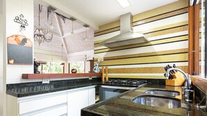 A kitchen with a stove, sink, and a backsplash with yellow and white tiles. - Bz37 House with Pool 200M from the beach! (Armação dos Búzios)