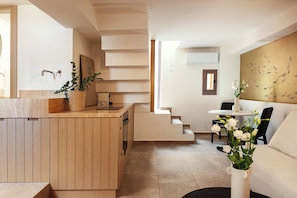 A modern kitchen with wooden cabinetry, a built-in stove, and a potted plant.