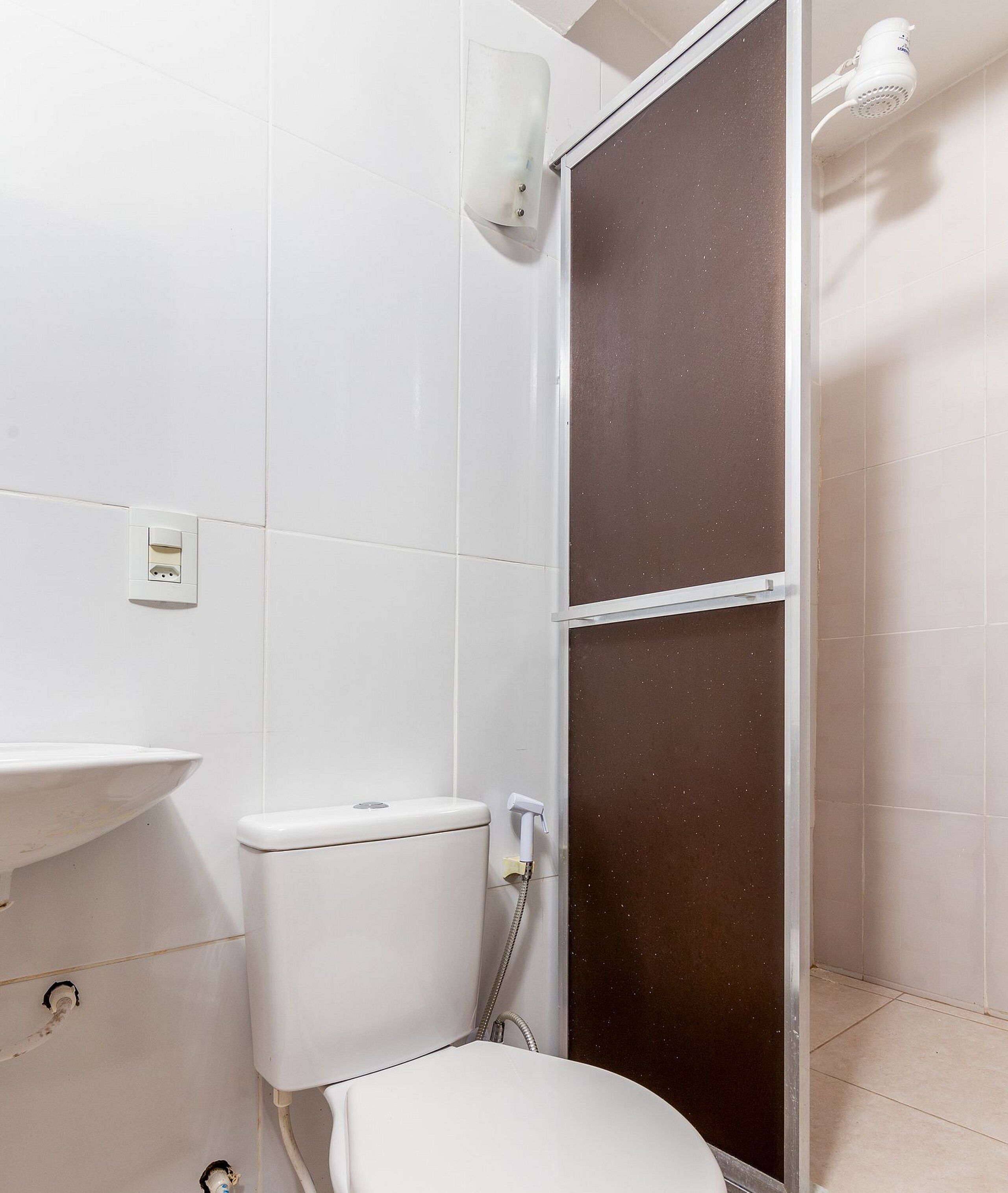 A bathroom with a toilet, sink, and shower.