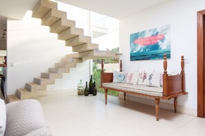 A staircase leading to a balcony, a wooden bench with cushions, and a motivational quote on the wall. - Bz 72! Sea View House with 5 suites and pool (Armação dos Búzios)