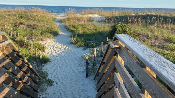 A wooden boardwalk leading to a sandy beach with a clear view of the ocean. - Charming beachfront villa in Hilton Head Island with pool, beach/pool bar & more (Hilton Head Island)
