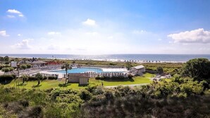 A resort with a large swimming pool, a tennis court, and a beach view. - Charming beachfront villa in Hilton Head Island with pool, beach/pool bar & more (Hilton Head Island)