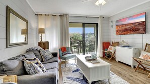 A modern living room with a grey sofa, a white coffee table, and a ceiling fan. - Charming beachfront villa in Hilton Head Island with pool, beach/pool bar & more (Hilton Head Island)