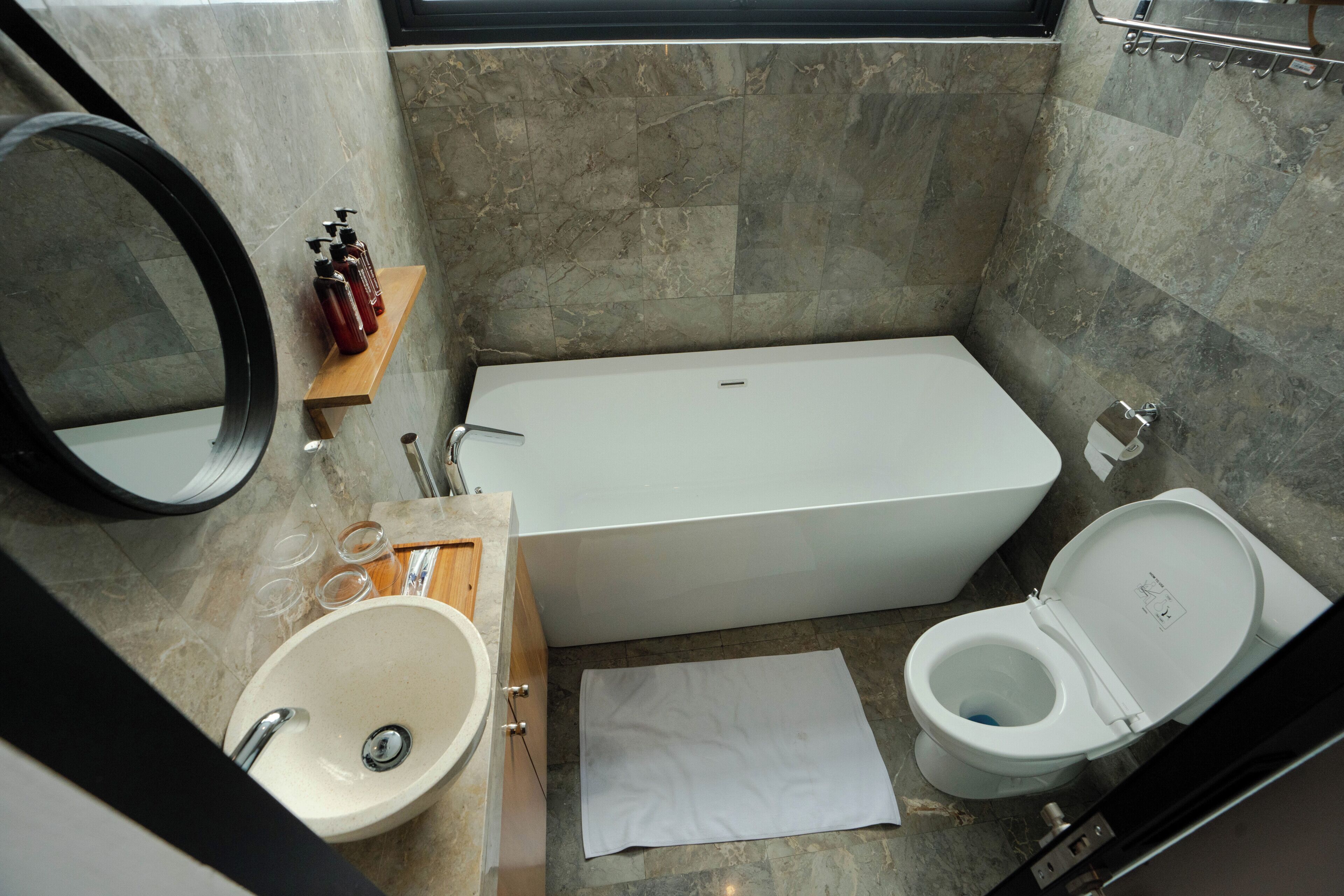 A bathroom with a sink, mirror, toilet, and bathtub.