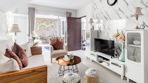 Una sala de estar moderna con sofá, sillón, mesa de centro, televisor y mueble.