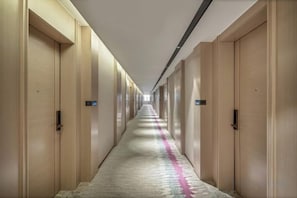 A long, narrow hotel corridor with wooden doors on both sides and a carpeted floor. - Galaxy Hotel (Beijing Wukesong Wanshou Road Subway Station Branch) (Beijing)