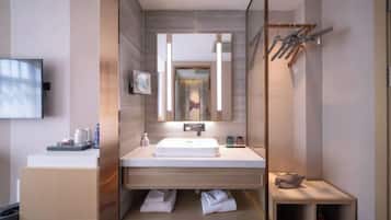 Un bagno moderno con uno specchio grande, un lavandino e una cabina doccia.