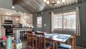 A spacious kitchen with wooden cabinets, a large island, and a dining area with a table and chairs.