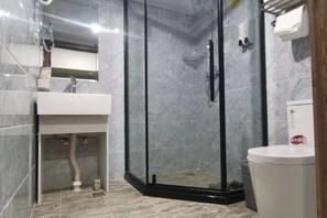 A bathroom with a glass-enclosed shower, a sink, and a toilet. - Sunshine Habitat Hotel (Dalian University of Technology) (Dalian)
