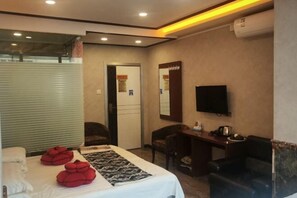 A hotel room with a bed, a desk, a chair, a TV, and a mirror. - Yichun Hongmeiqi Express Hotel (Yichun)
