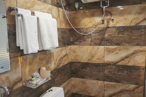 A bathroom with marble tiles, a shower, and a towel rack with white towels. - Yichun Hongmeiqi Express Hotel (Yichun)