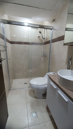 A modern bathroom with a glass-enclosed shower, a white toilet, and a sink with a mirror above it. - New 4 star apartment in prime location (2025), Just a few steps away from Bars, Restaurants, Shoppin... (Pampatar)