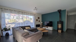A living room with a sofa, a TV, a small table, and a fireplace.